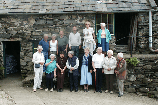 Group photo in front of historic house for the Kirkby History Group